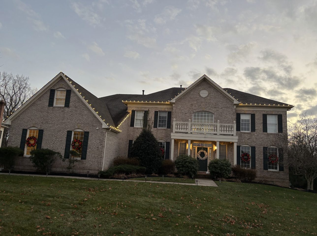 Christmas lighting installation with roofline and landscape accents